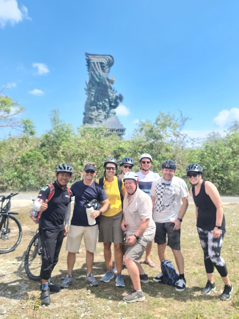 Group of riders on UNIKAT e-bikes near the GWK statue in Bali