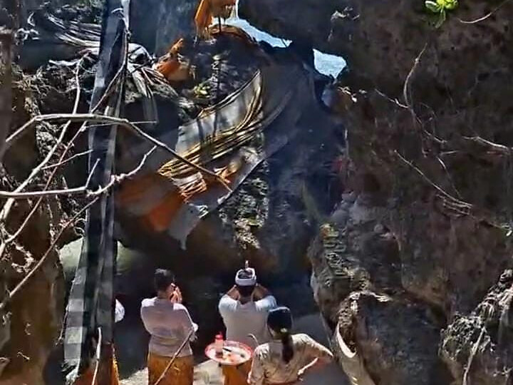 Sacred cliff shrine at Pura Geger with ceremonial offerings