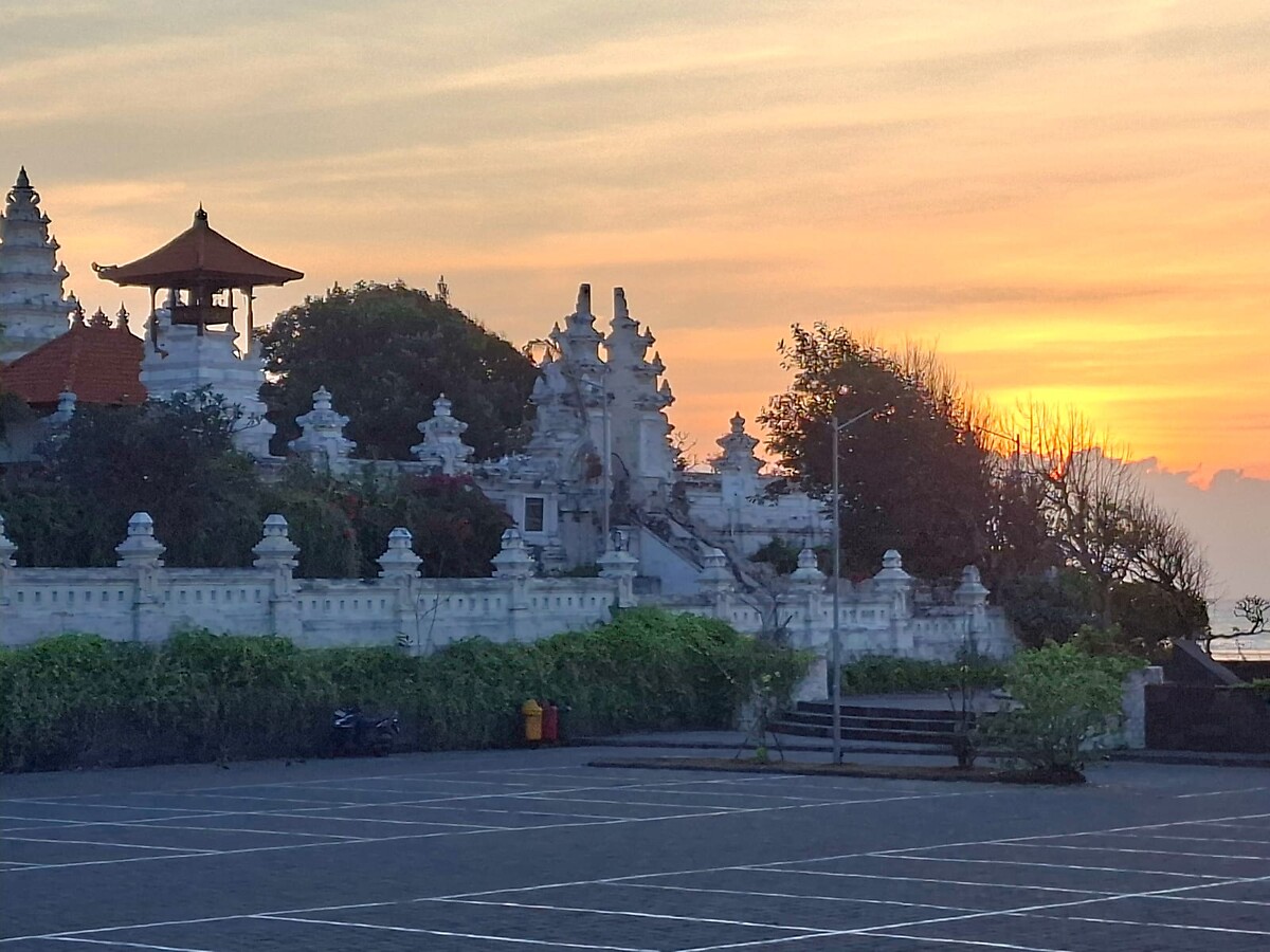 Pura Geger temple silhouette against a golden sunset sky in Nusa Dua