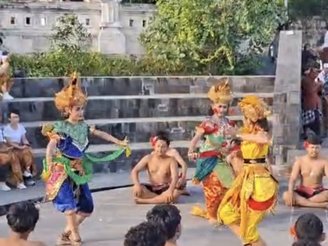 Colorful Balinese dancers performing a traditional sunset dance
